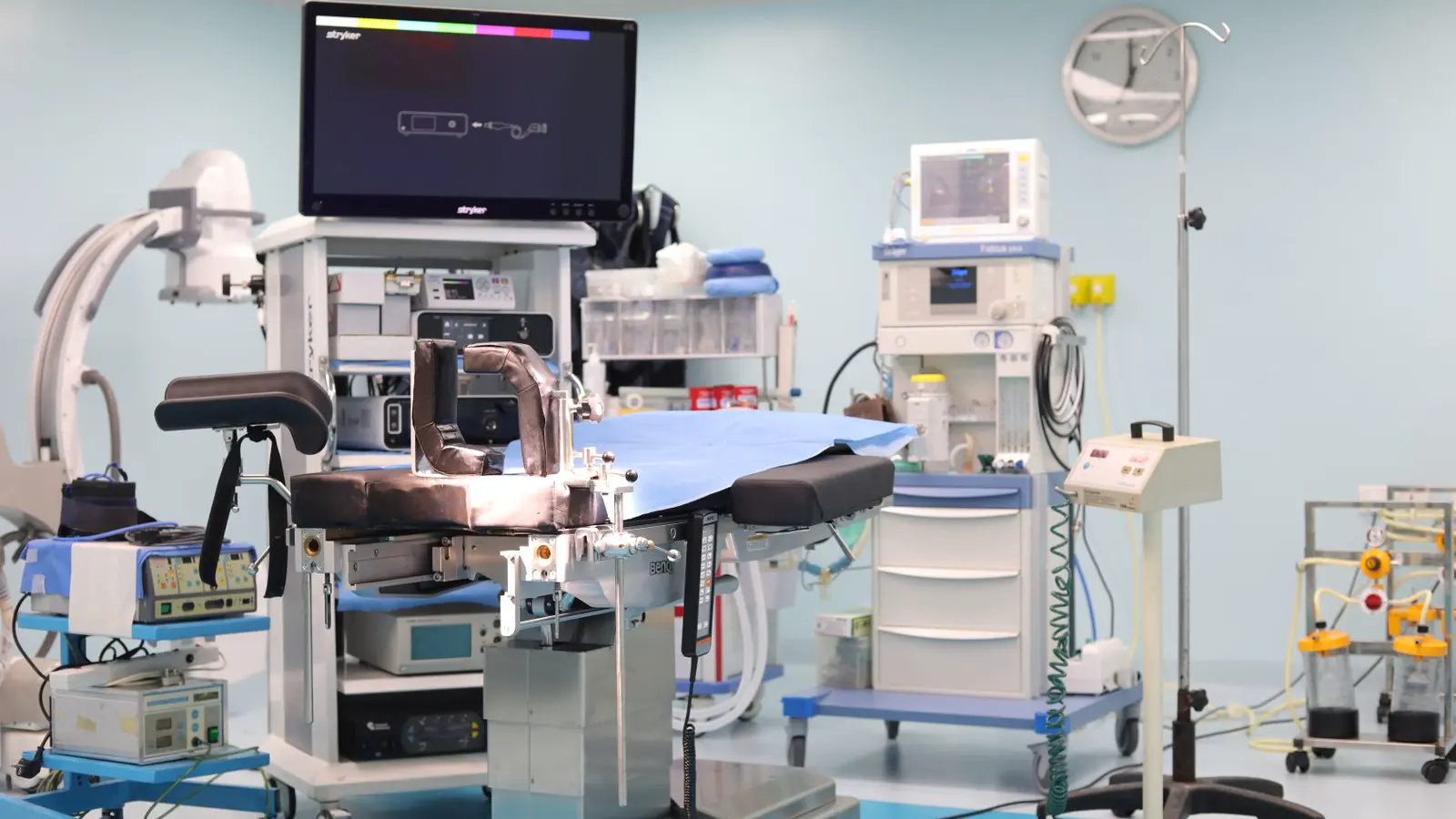 Empty operating room with an operating table, anesthesia machine and monitors