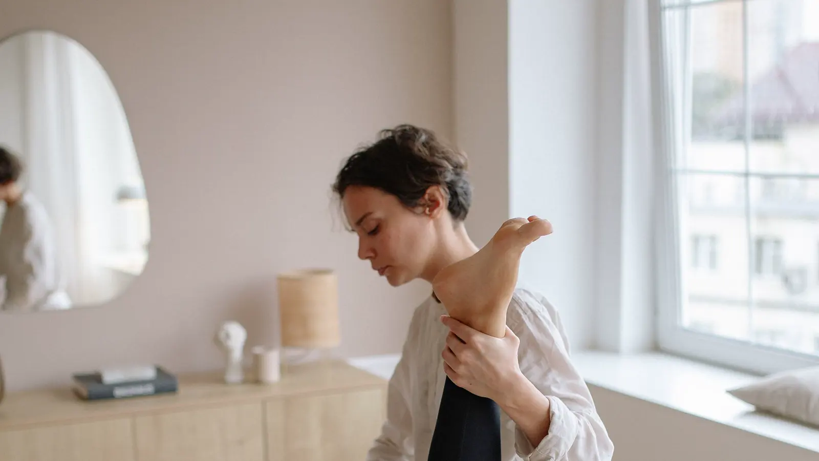 Physiotherapist supporting a patient's leg during a pelvic health physical therapy session